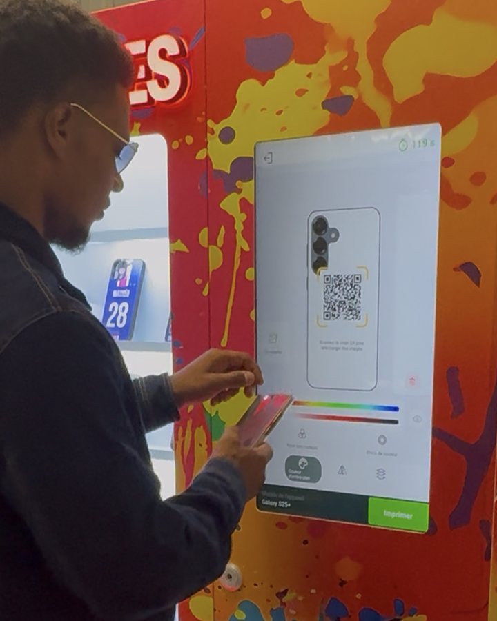Un client scanne le QR code affiché par le distributeur avec son téléphone pour envoyer sa photo